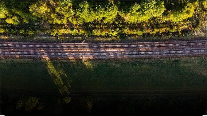 Aerial view of a rail corridor through greenery — drone corridor surveying